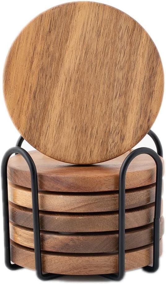 Six round acacia wood coasters in a matching wooden holder on a coffee table, one pulled out under a glass of water