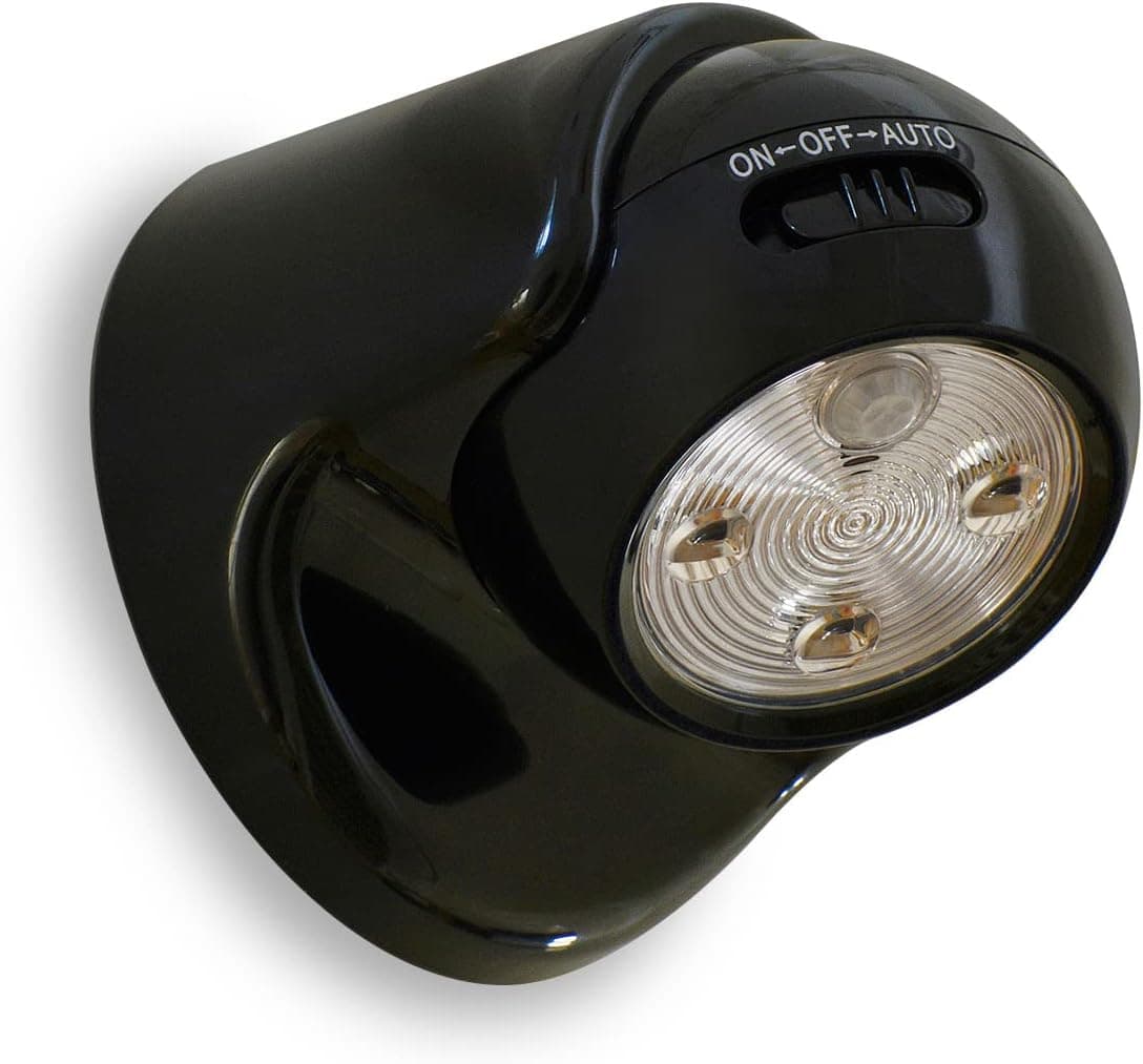A small black battery-powered motion sensor light, a rounded square lamp head on a swivel wall base