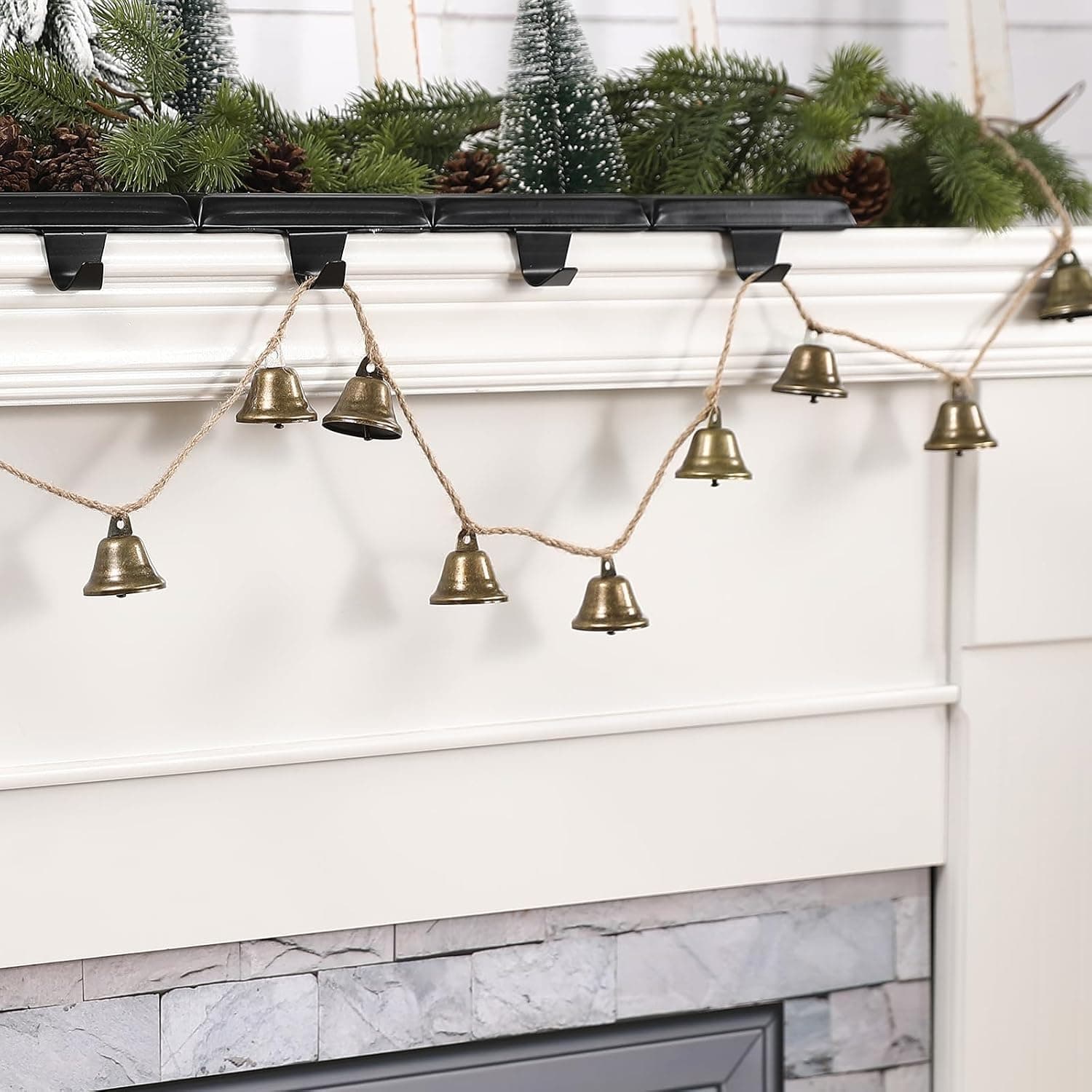 A string of small bronze-finish bells on natural jute rope wound round the white newel post at the foot of a staircase