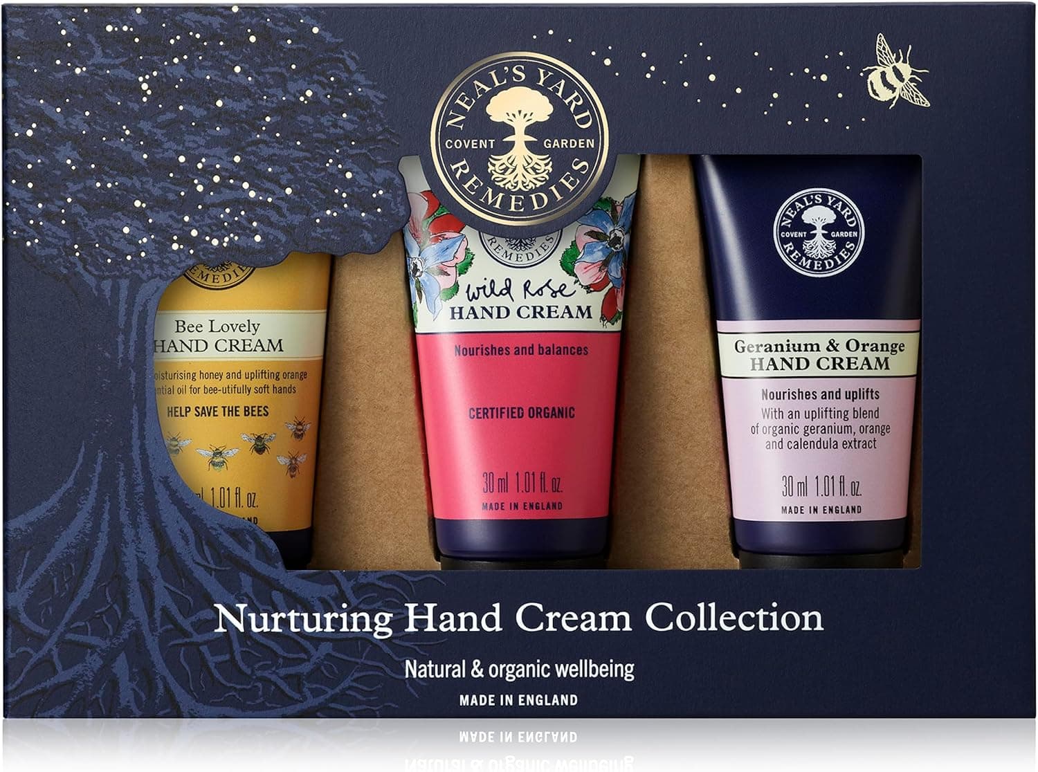 A navy Neal's Yard Remedies gift box holding three 30ml hand cream tubes: Bee Lovely, Wild Rose and Geranium & Orange