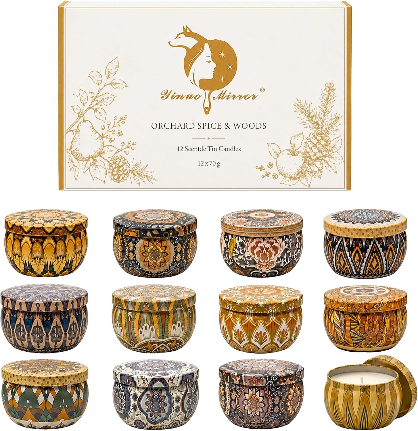 Twelve small patterned candle tins in a presentation box, one open and lit on a wooden desk beside a mug
